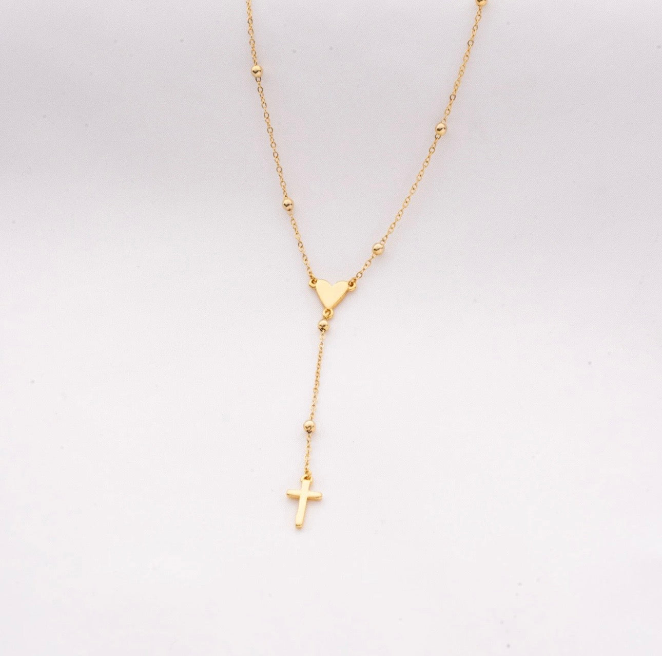 Cadena rosario con dije de corazón.
